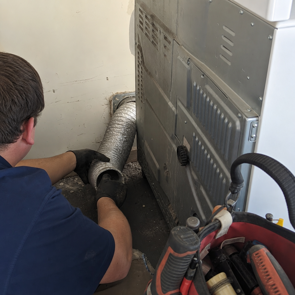 Technician performing professional dryer vent cleaning and maintenance service
